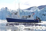 Longyearbyen Lokalstyre, Svalbard - The crew film off the back off The Arctic Explorer Leone as it sits against a backdrop of glaciers in Svalbard.  (photo credit: National Geographic)