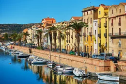 River embankment with typical colorful Italian houses on a street of Bosa, Sardinia, Italy
