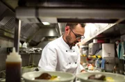 Koch Sean Casey bereitet edle Speisen auf engstem Raum zu.