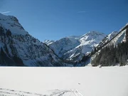 Im Winter ist der See dick zugefroren, so dass Skiläufer und Wanderer über ihn hinweg laufen. Im Winter ist der See dick zugefroren, so dass Skiläufer und Wanderer über ihn hinweg laufen.