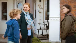 Jannis (Lewe Wagner, li.) und seine Mutter Eva (Zoe Moore, re.) werden von Frau Schmitz (Dagmar Leesch) betreut.