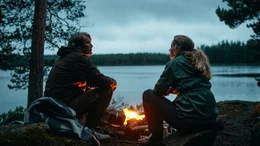 Martin (Mads Mikkelsen, li.) sitzt mit Anika (Maria Bonnevie) am Lagerfeuer.