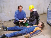 Kranf&uuml;hrer Rainer Stoll (Philipp Moog, liegend) verungl&uuml;ckte auf der Baustelle. Dr. Stefan Frank (Sigmar Solbach, li.) versucht ihm zu helfen. Die Zeit dr&auml;ngt, denn der Beton wird rasend schnell hart ...