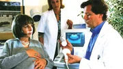 Dr. Stefan Frank (Sigmar Solbach) untersucht seine hochschwangere Patientin Dr. Ursula Ronacher (Michaela May, li.). Carmen (Sophie Sch&uuml;tt, hi.) assistiert ihm.