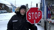 Male holds a stop sign and looks into the camera. Male holds a stop sign and looks into the camera.