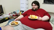 Tommy lays in bed with food