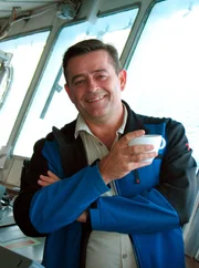 Kreuzfahrtdirektor Thomas Glei&szlig; mit Kaffee auf der Br&uuml;cke.