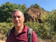 Guido Giordano vor einem vulkanischen Felsen (Landschaft).