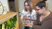 Tauschmutter Monika (li.) ekelt sich vor der Echse, die Anna ihr in die Hand geben will..Tauschmutter Monika (li.) ekelt sich vor der Echse, die Anna ihr in die Hand geben will..