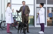 Holger Meyer (J&ouml;rg Bundschuh, M.) m&ouml;chte zu seiner Frau. Er bittet Julia Berger (Mirka Pigulla, l.) und Dr. Leyla Sherbaz (Sanam Afrashteh, r.) auf seine H&uuml;ndin "Petra" aufzupassen.