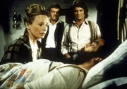 Grace Edwards (Bonnie Bartlett, l.) kniet am Krankenbett ihres Mannes Isaiah (Victor French). Dr. Baker (Kevin Hagen, M.) und Nachbar Charles Ingalls (Michael Landon, r.) stehen ihr zur Seite.