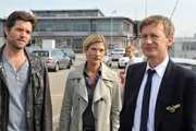 Jo Stoll (Peter Ketnath, l.) und seine Chefin Martina Seiffert (Astrid M. F&uuml;nderich, 2.v.l.) befragen den Piloten Kai-Uwe Maassen (Jan Henrik Stahlberg, r.) am Flughafen; seine Frau Bea (Komparsin, 2.v.r.) steht im Hintergrund.