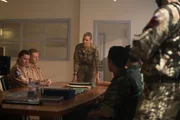 Auf der Basis in Wudyan, die ebenfalls in die Drohnenschau involviert war, befragt Squadron Leader Eliza Russell (Romola Garai, M.) ihr Personal. (Komparsen im Bild)