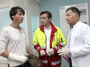 Gero Quitte (Ralph Kretschmar, links) erkundigt sich bei dem Notarzt (Markus Neumann, Mitte) und Dr. Roland Heilmann (Thomas R&uuml;hmann) nach dem Zustand der eingelieferten Patientin Marlene Defland.