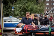 Jetzt ist Eile geboten: W&auml;hrend der Behandlung durch Dr. Haase (Fabian Harloff, 2.v.l.) verliert der Kurierfahrer Jan Wojcik (Kai M&uuml;ller) das Bewusstsein.