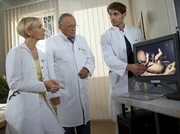 Prof. Simonis (Dieter Bellmann, mi.) Tochter Rebecca ist schwanger und ihr Kind muss im Mutterleib operativ von einem amniotischen Band befreit werden. Dr. Niklas Ahrend (Roy Peter Link, re.) erkl&auml;rt ihm die Operation. Da Rebecca Diabetikerin ist, besteht ein erh&ouml;htes Narkoserisiko. Dr. Kathrin Globisch (Andrea Kathrin Loewig, re.) hat bei der K&uuml;rze der OP keine Bedenken, doch Simoni sorgt sich v&auml;terlich.