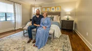 Ben and Erin Napier sit in the beautifully renovated primary featuring the DIY botanical art above the bed, as seen on Home Town, Season 8.