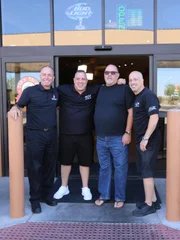 Wayde und Brett posieren drau&szlig;en am Thumb mit Besitzer Kip Lassetter und General Manager Mike Lawson.