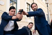 Staatssekret&auml;r Thomas Farber (Thomas Unger, M.) und die Personensch&uuml;tzer des LKA, Mascha Turger (Tanja Hirner, l.) und Wolfgang M&uuml;ritz (Matthias Weidenh&ouml;fer, r.), stehen vor dem Parlamentsgeb&auml;ude unter Beschuss.