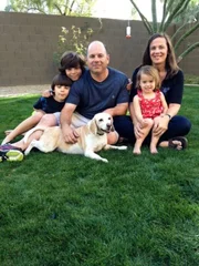 The Scheinerman family sitting outside with their dog, Lucy.