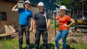 Michael (left) Mike Holmes (center) and Sherry (right) pose with tools in front of a farm house that needs some serious work as seen on HGTV's Holmes Family Rescue Season 2.