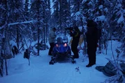 The crew recording Heimo as he attempts to repair his snowmobile.