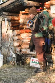 Tyler in front of a cabin with a puppy.