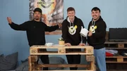 Was l&auml;sst sich mit Pfandgut alles anstellen, bevor man es endg&uuml;ltig zur&uuml;ckgibt? Tommy (links), Vincent (Mitte) und Moritz (rechts) bauen aus Europaletten einen Tisch und lassen es sich erstmal gut gehen, bevor sie die Paletten wieder zur&uuml;ckgeben.