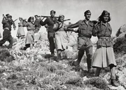 Eine Reihe griechischer Partisanen, Männer und Frauen, marschieren auf einem Pfad auf einem Hügel in der Nähe von Athen, um sich den alliierten Truppen anzuschließen, die gerade gelandet sind. In der Nähe von Athen (Griechenland), Oktober 1944. Eine Reihe griechischer Partisanen, Männer und Frauen, marschieren auf einem Pfad auf einem Hügel in der Nähe von Athen, um sich den alliierten Truppen anzuschließen, die gerade gelandet sind. In der Nähe von Athen (Griechenland), Oktober 1944.
