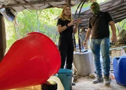 Mariana van Zeller (L) talking with masked individual in a secret meth lab. (Credit: National Geographic)