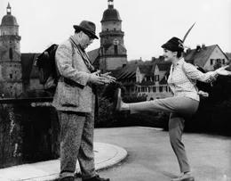 Immer neue &Uuml;berraschungen gibt es f&uuml;r Gottlieb S&auml;nger (Heinz Erhardt). Nicht nur , da&szlig; Kiki (Christine Kaufmann) ihn auf seiner Fu&szlig;wanderung begleiten wird; Sie hat sich auch z&uuml;nftig daf&uuml;r eingekleidet.