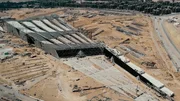 Blick von oben auf die riesige Baustelle des Grand Egyptian Museums mit der Stadt Kairo im Hintergrund.