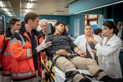 Bei der Einlieferung von Juan Martinez (Rahul Chakraborty, 3.v.r.) durch Dr. Haase (Fabian Harloff, 2.v.l.) stellt sich heraus, dass der Patient am Dengue-Virus erkrankt sein k&ouml;nnte. Dr. Jonas (Gerit Kling, r.) ordnet weitere Vorkehrungen an.