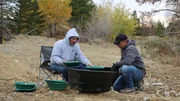 Dave Turin and Mark McDonough wash out some goldpans in a large bucket