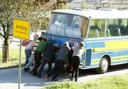 Mit vereinten Kr&auml;ften schieben die Pilger ihren defekten Bus ins n&auml;chste Dorf.