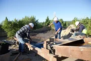 Jesse Goins & Jason Sanchez fixing sluice with camera operator in background