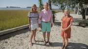 As seen on HGTV's Beach Hunters, homebuyers Tara and Rick and realtor Angela Johnson pose for a photo after touring the Sail Away House in Fripp Island, South Carolina.
