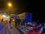 Two heavily loaded trailers have collided, head on head on an icy road.