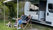 Svenja (r) und Jan Kr&uuml;ger vor ihrem Glamping Van auf einem Campingplatz in den D&uuml;nen von Nordholland.