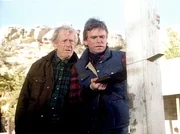 Harry (John Anderson, l.) beobachtet, wie MacGyver (Richard Dean Anderson, r.) einen Verandapfosten ans&auml;gt, um die &Uuml;berlebenschancen zu vergr&ouml;&szlig;ern.