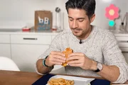 Tobias Müller isst einen Burger. Tobias Müller isst einen Burger.