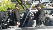 Mehrere AMO-Agenten sitzen auf einem Wasserfahrzeug und bereiten sich auf eine Suche auf dem Meer vor.