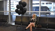 Tigerlily Taylor is sitting with balloons and waiting at the airport in Texas