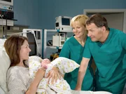 Bei Elena Eichhorn (Cheryl Shepard, links) sind nach einer schwierigen Entbindung innere Blutungen aufgetreten. Dr. Roland Heilmann (Thomas R&uuml;hmann, rechts) und Dr. Kathrin Globisch (Andrea Kathrin Loewig) bekommen die lebensbedrohlichen Komplikationen in den Griff und freuen sich, ihr eine gesunde Tochter in die Arme legen zu k&ouml;nnen.