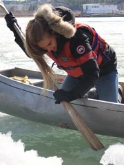 Molly maneuvers a canoe through icy water.