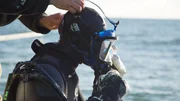 Andy Kelly helps Kris Kelly with his dive mask.
