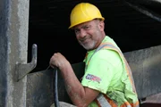 Chris Doumitt smiling at the excavator.