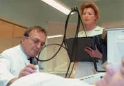 Prof. Simoni (Dieter Bellmann) bekommt w&auml;hrend einer Untersuchung von Oberschwester Ingrid (Jutta Kammann) die Nachricht von der Einlieferung Reimers.
