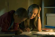Constanze (Henrieke Fritz) hilft ihrem kleinen Bruder Dominik (Yannick Rau) bei den Hausaufgaben.