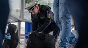 Bundespolizist Dennis Hehemann durchsucht die Tasche eines Verd&auml;chtigen.